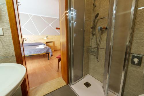阿尔塔泰尔梅Hotel Park Oasi的带淋浴的浴室和卧室