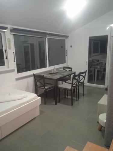 卡利诺岛Kalymnos Platy Gialos Mousellis Makis Apartments的一间带桌椅和窗户的用餐室