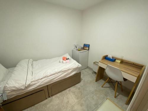 曼彻斯特Airstaybnb的一间卧室,配有一张床和一张桌子,里面放着一只动物