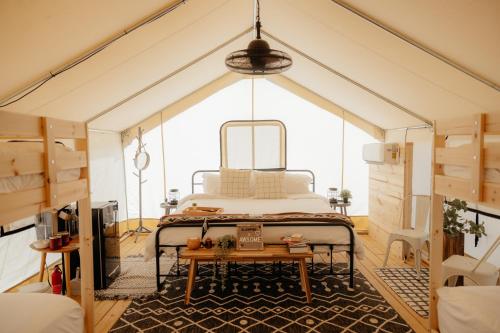 甘特斯维尔Deluxe Glamping Tents at Lake Guntersville State Park的帐篷内的卧室,配有一张床和一张桌子