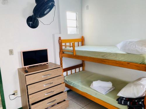 托雷斯Parada da Cal Beach Torres的一间卧室配有两张双层床和电视