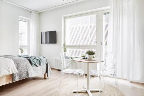 坦佩雷Beautiful apartment in the center of Tampere的卧室配有一张床和一张桌子及椅子