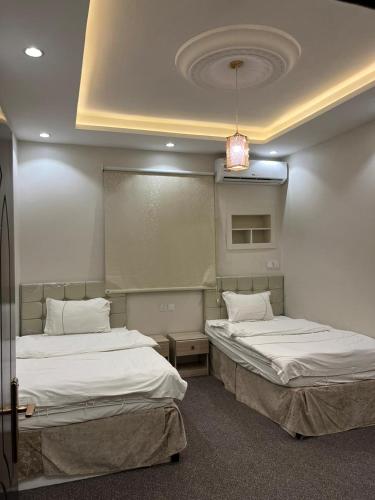 Ukazهابي دريم للشقق المخدومة的客房设有两张床和吊灯。