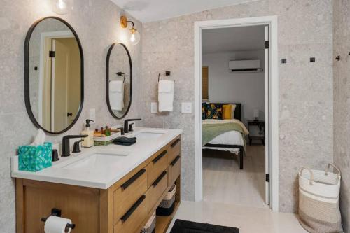 盖恩斯维尔Smart Bungalow: 10-min to UF, Central Location的一间带水槽和镜子的浴室以及一张床