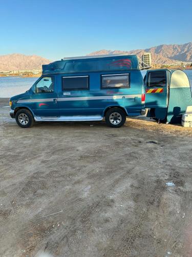 埃拉特הקראוון של תומר的一辆蓝色卡车,装有野营车和帐篷