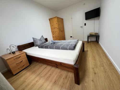 诺登哈姆Traumhafte Ferienwohnung zentral的一间卧室配有一张床和一个木制梳妆台