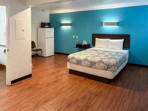 安大略Motel 6的一间卧室设有一张床和蓝色的墙壁
