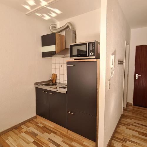 特里尔Zentrales Apartment mit Balkon und Parkplatz的厨房配有冰箱上方的微波炉