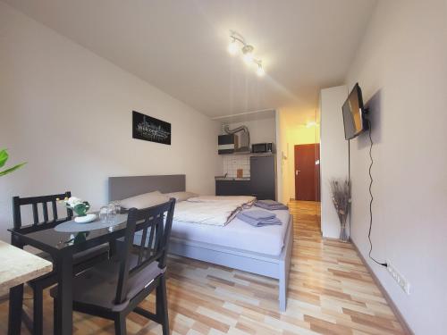 特里尔Zentrales Apartment mit Balkon und Parkplatz的一间卧室配有一张床铺和一张桌子,还有一间用餐室