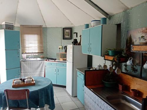 Lafrenz TownshipNoble Luminous Accommodation & Tours的厨房配有蓝色橱柜和桌子