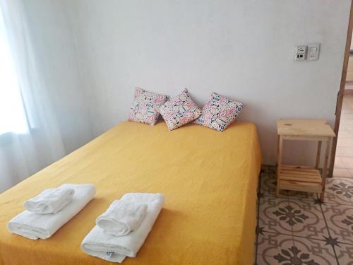 卢汉德库约Rincón Verde Chacras de Coria的一间卧室配有黄色的床和毛巾