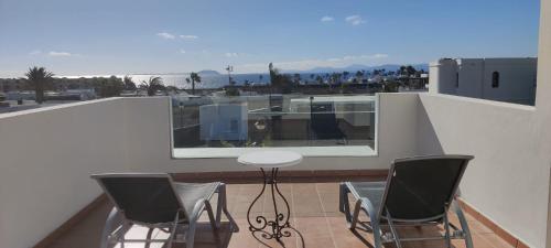 普拉亚布兰卡Villa Sunset Faro Deluxe & Spa Pool的屋顶阳台配有桌椅