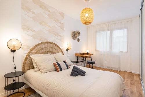 里昂Les Cocons Montchat的一间卧室配有一张带两盏灯的大型白色床。