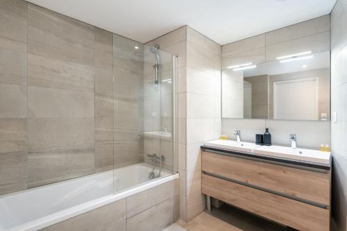 里昂Les Cocons Montchat的带浴缸、水槽和镜子的浴室