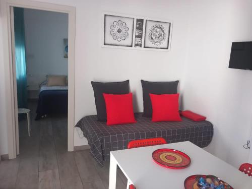 贝赫尔-德拉弗龙特拉Casa Patio Paraíso的客厅配有带红色枕头和桌子的床
