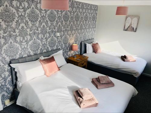 邓弗姆林Springbank Holiday Home的两张位于酒店客房的床,配有毛巾