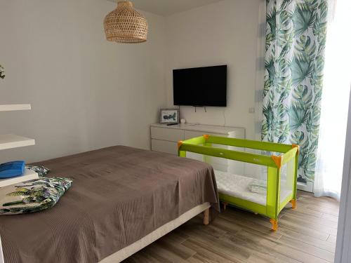 阿祖罗港Il PolpoLeo in Porto Azzurro Isola d'Elba的一间小卧室,配有一张床和电视