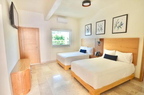 里奥韦尔德Hotel Plaza Rioverde的一间卧室设有两张床和窗户。