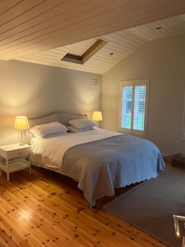Ballymoney Cross RoadsBallymoney, Wexford - 3 bed beach house with private beach access的一间卧室配有一张带两盏灯的床。
