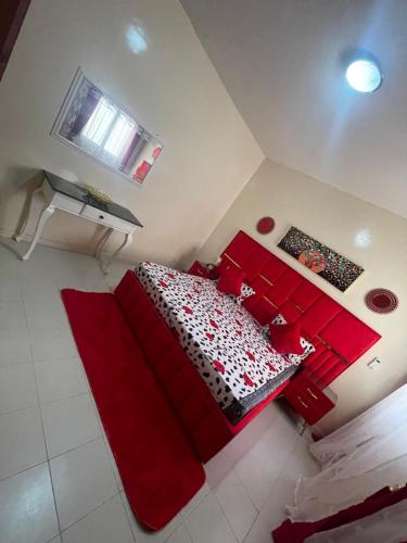 NgorLuxe et confort a ngor dans un quartier très accessible的一间卧室配有红色的床和红色枕头