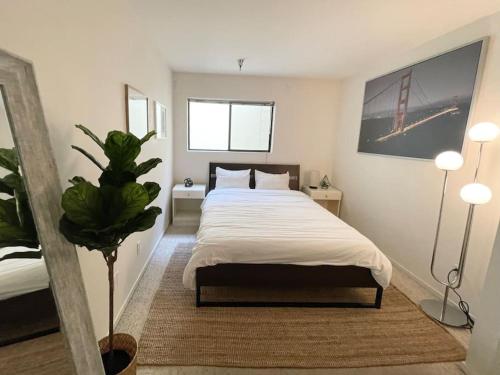 旧金山Bright Spacious & Comfortable Hayes Valley Condo的一间卧室配有一张床和盆栽植物