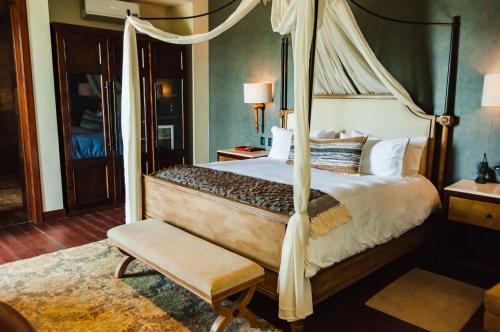 Los GalvanesCasa Raíces Hotel Luxury & Viñedo的一间卧室配有一张天蓬床和一把椅子