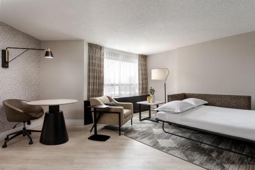 多瓦尔蒙特利尔机场喜来登酒店的配有一张床、一张桌子和一张桌子的酒店客房