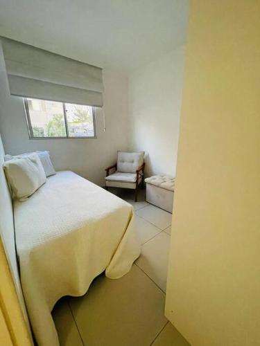 贝洛奥里藏特Apto VIP em frente à ARENA MRV / Expominas的卧室配有床、椅子和窗户。