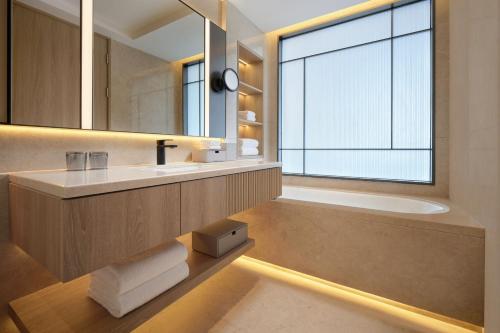 上海上海西藏大厦万怡酒店的浴室配有盥洗盆、镜子和浴缸