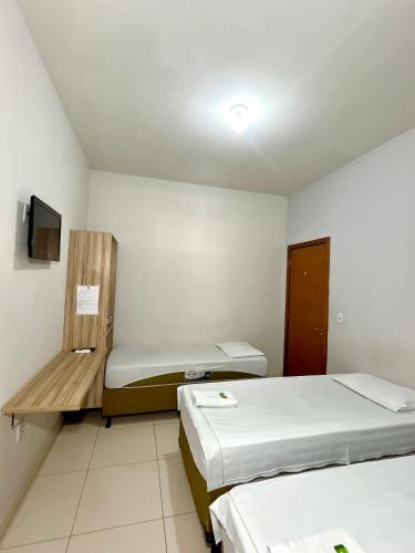 大瓦尔泽亚Kitnet Realeza的小房间设有两张床和电视