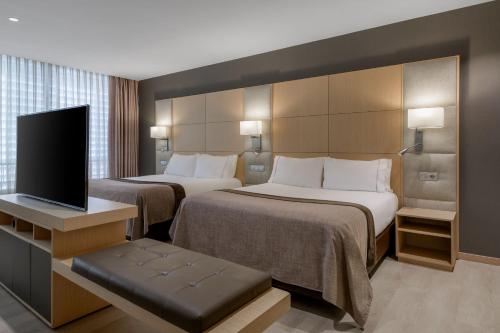 巴塞罗那维多利亚套房万豪AC酒店的酒店客房设有两张床和一台平面电视。