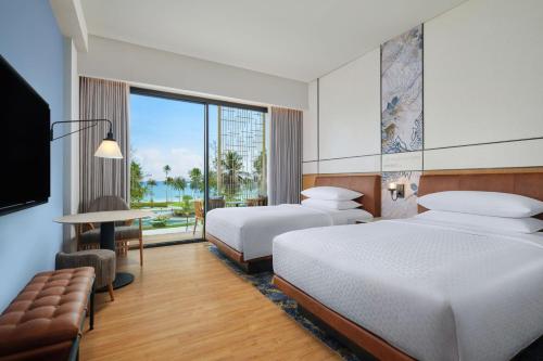 拉古洼Four Points by Sheraton Bintan, Lagoi Bay的酒店客房设有两张床和电视。