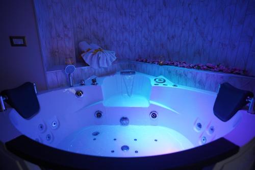 拉戈帕特里亚REDAMARE SUITE的紫色照明的房间内的大型白色浴缸