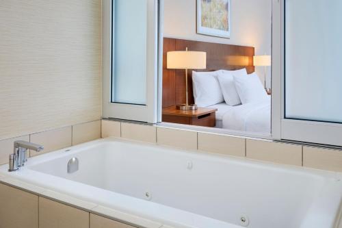 渥太华渥太华卡纳塔费尔菲尔德套房客栈的带浴缸的酒店客房 - 带一张床