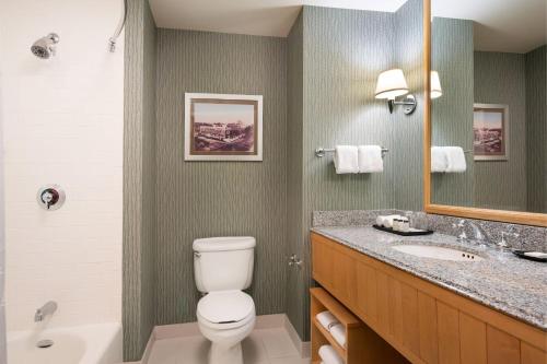 萨克拉门托萨克拉门托喜来登大酒店的一间带卫生间、水槽和镜子的浴室