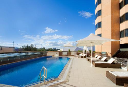 阿德莱德阿德莱德洲际酒店的一座带椅子和遮阳伞的游泳池
