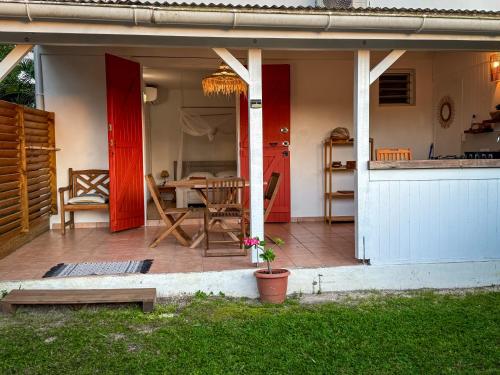 大博格Gîte Ti Carbet - Vue mer的一座房子,设有红色的门,庭院里设有一张桌子