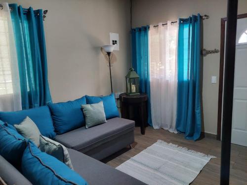 圣克鲁斯德约霍阿La Casita del Lago en El Jaral的客厅配有蓝色的沙发和蓝色的窗帘