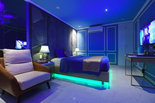 岘港Chiic House 1 - Khách sạn tình yêu的一间卧室配有一张床、一把椅子和电视。