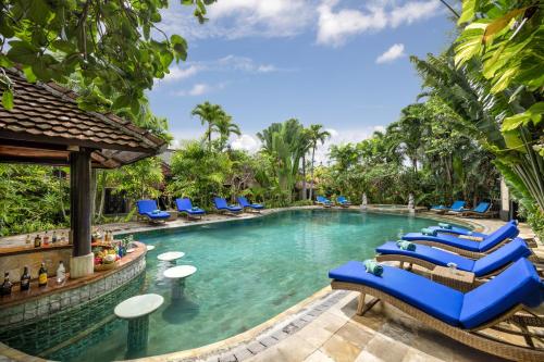 塞米亚克Tonys Villas & Resort Seminyak - Bali的一个带蓝色躺椅的度假村游泳池