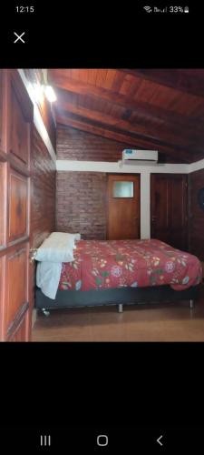 萨尔塔la soñadita的木制客房内的一间卧室,配有一张床