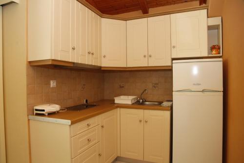 劳德哈塔雷蒙娜酒店的厨房配有白色橱柜和白色冰箱。