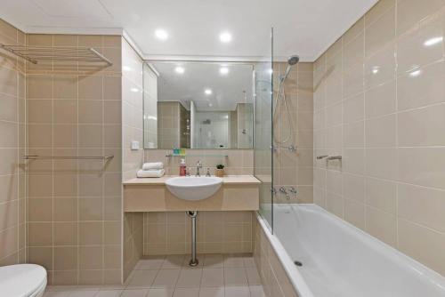 悉尼Comfy Studio Next to Chatswood Station的一间带水槽、浴缸和卫生间的浴室