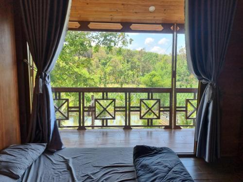 邦美蜀An Nhien Farm - Venuestay的一间卧室,享有带一张床的阳台的景色