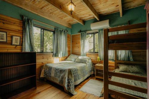 哈拉瓦科阿Villa Ka: Relax with fresh air and mountain view.的一间卧室配有一张床和两张双层床。
