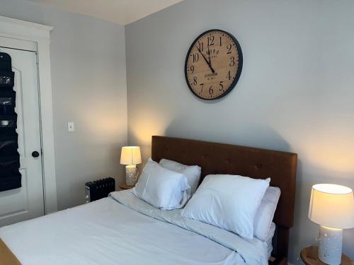斯普林菲尔德Perfect stay for couples的床上方的墙上挂着一个时钟,上面有枕头