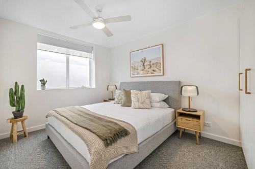 墨尔本Stylish 2- Bedroom Unit near parks, shopping and dining的白色的卧室设有床和窗户