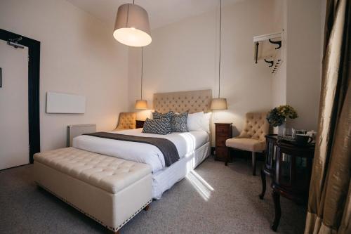 维多利亚山Hotel Etico at Mount Victoria Manor的一间卧室配有一张大床和一把椅子