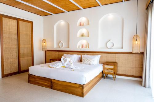 海神庙Shanti Boutique Retreat的一间卧室配有一张带白色床单的大床