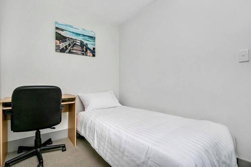 悉尼SX339 - CBD Chinese Gardens Views, Modern 2BR Apt的一间卧室配有书桌、一张床和一把椅子